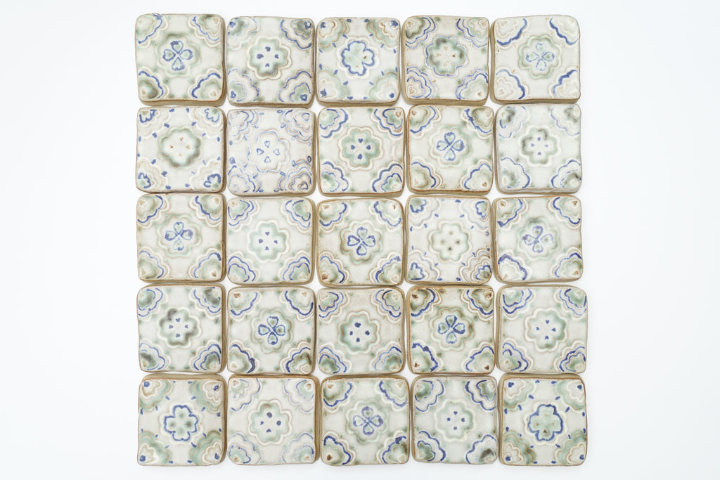 Patterned ceramic tiles arranged in a grid on a white background