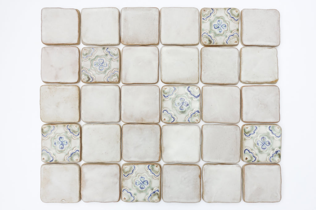 A blend of plain and decorative ceramic tiles on a white background