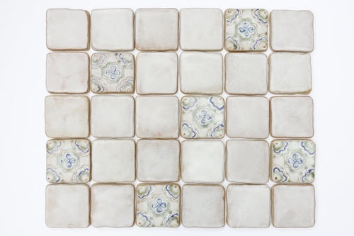 A blend of plain and decorative ceramic tiles on a white background