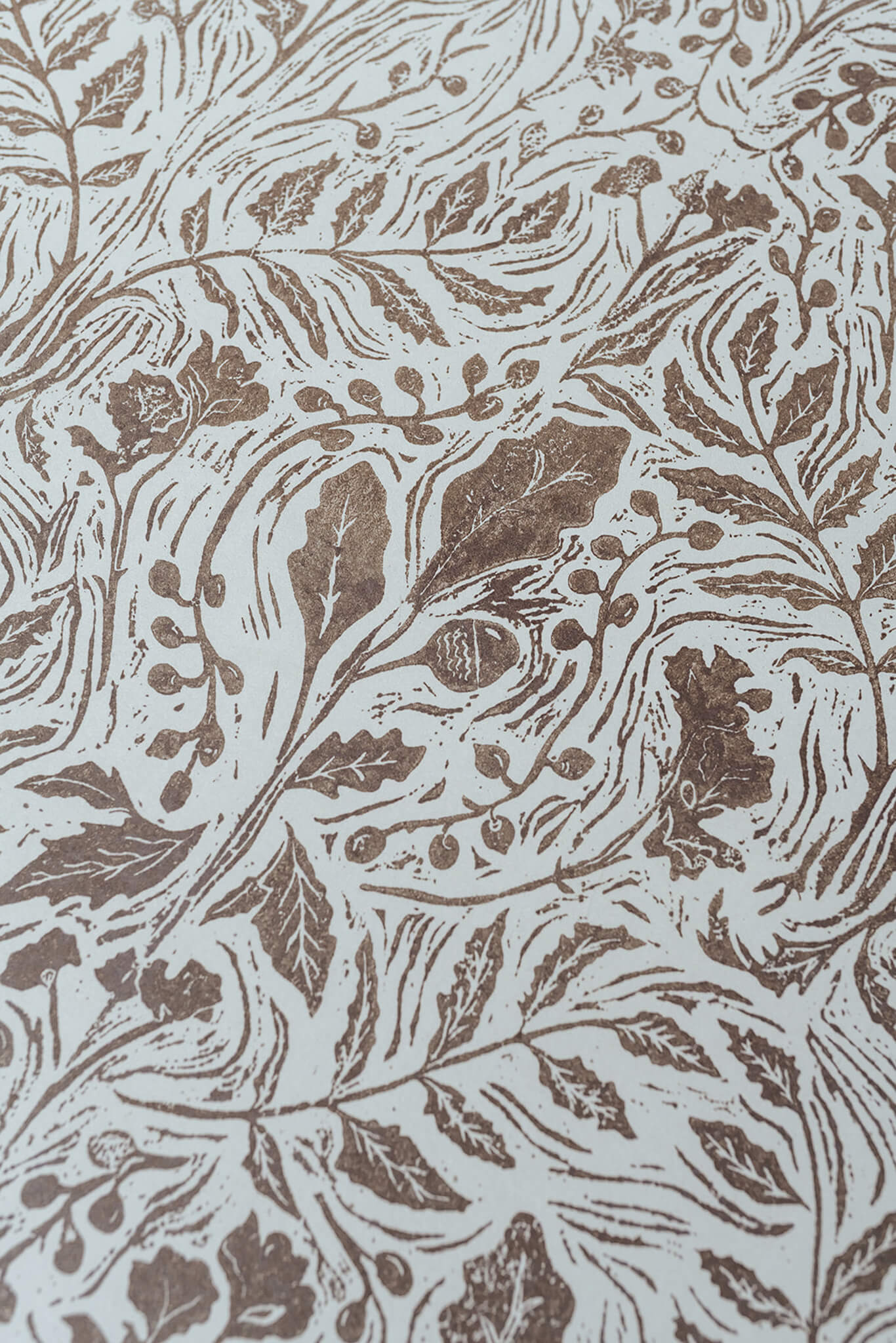 Decorative wallpaper pattern with brown leaves and flowers on a beige background